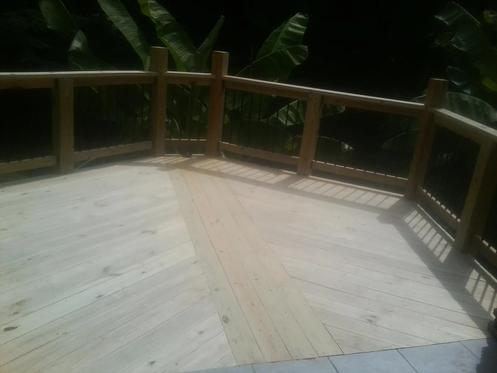 New wood deck and railing built off the back of a home in Oak Grove