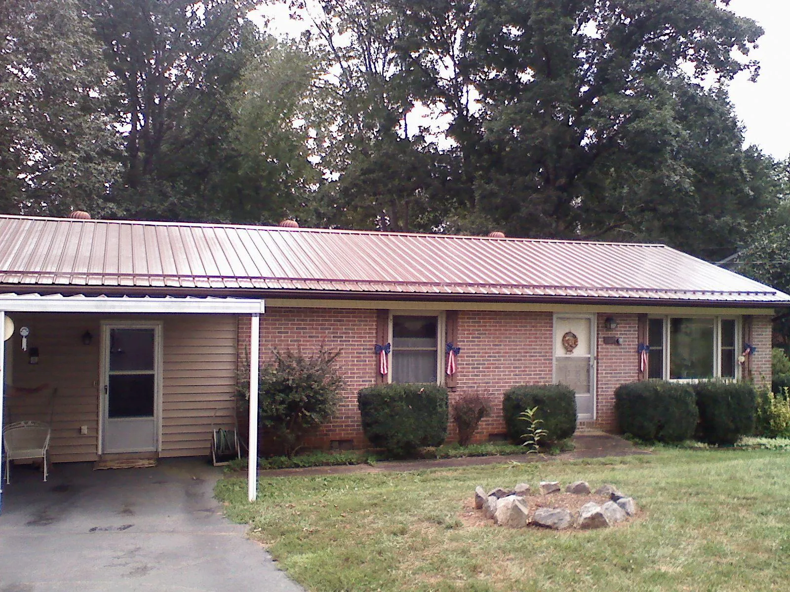 Bronze metal roof and carport on a brick ranch home — Roof Repair work by our crew in Oak Grove