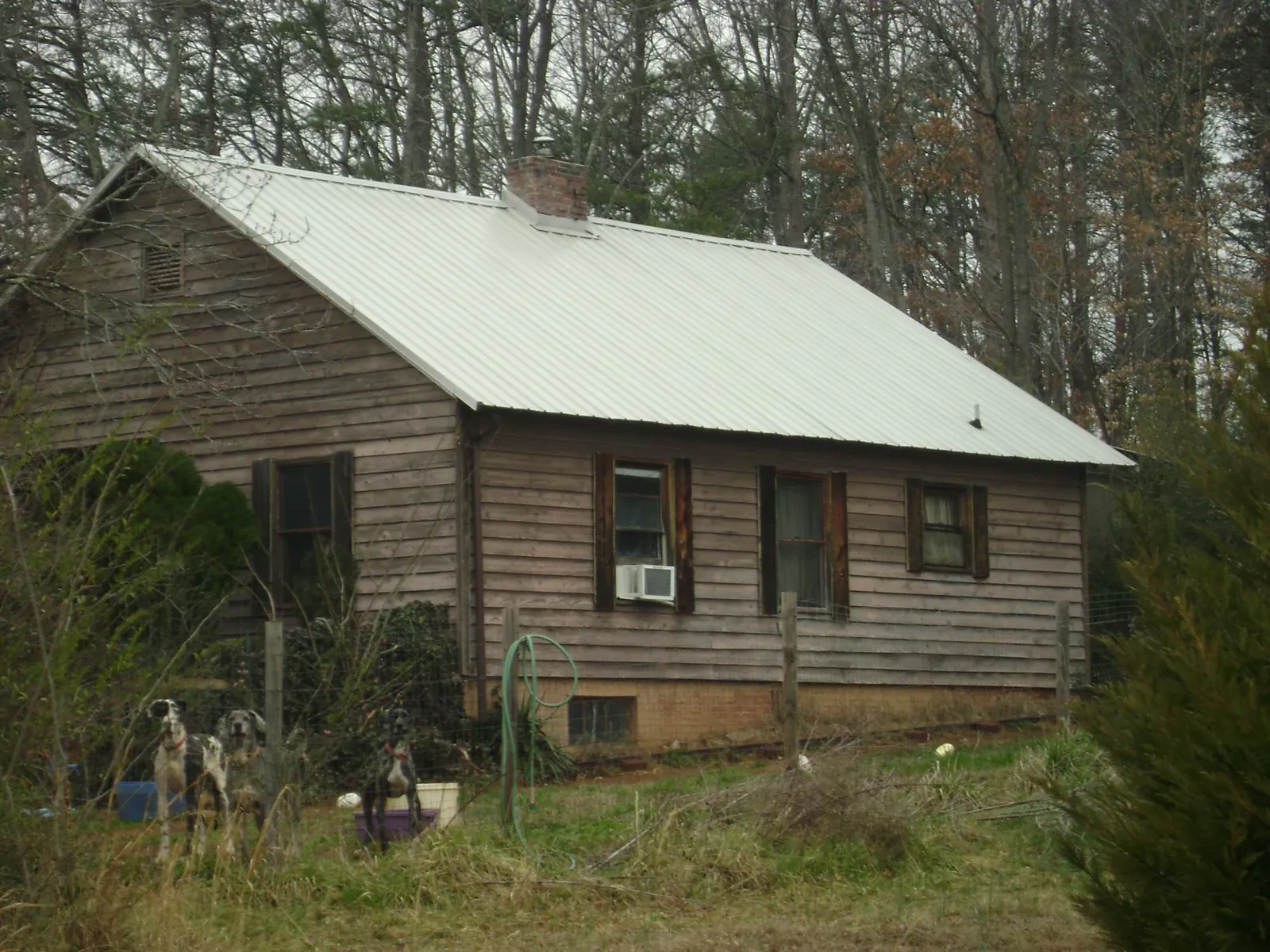 White metal roof on an old wood sided farmhouse, from a Metal Roof Installation job in Oak Grove